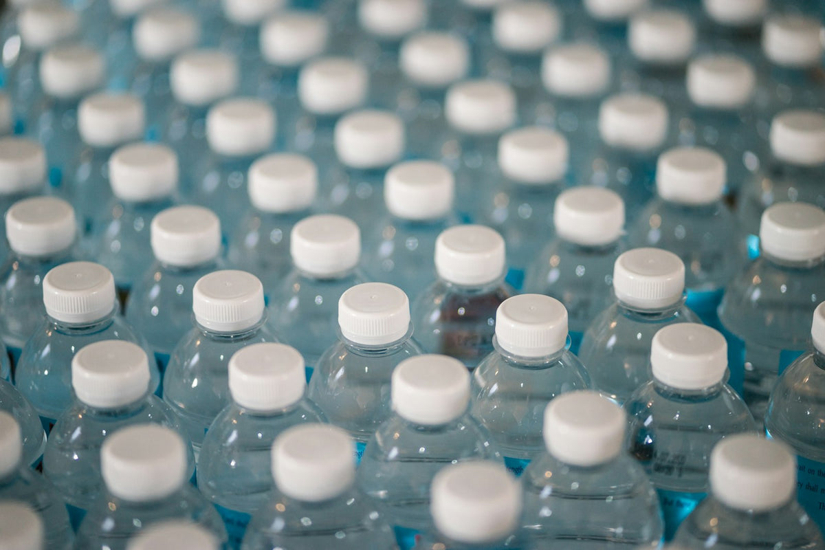 Overhead view of many plastic water bottles, representing the cost and waste of a daily bottled water habit