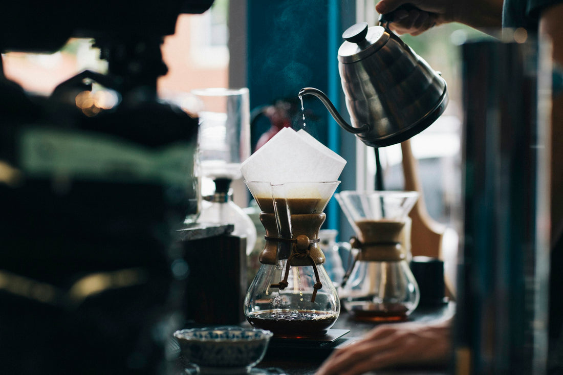 Pouring hot water over coffee grounds in a pour-over brewer