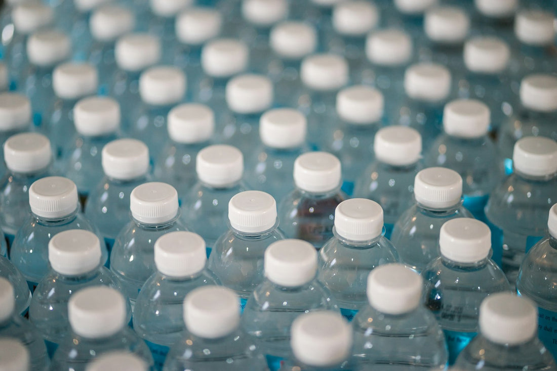 Overhead view of many plastic water bottles, representing the cost and waste of a daily bottled water habit