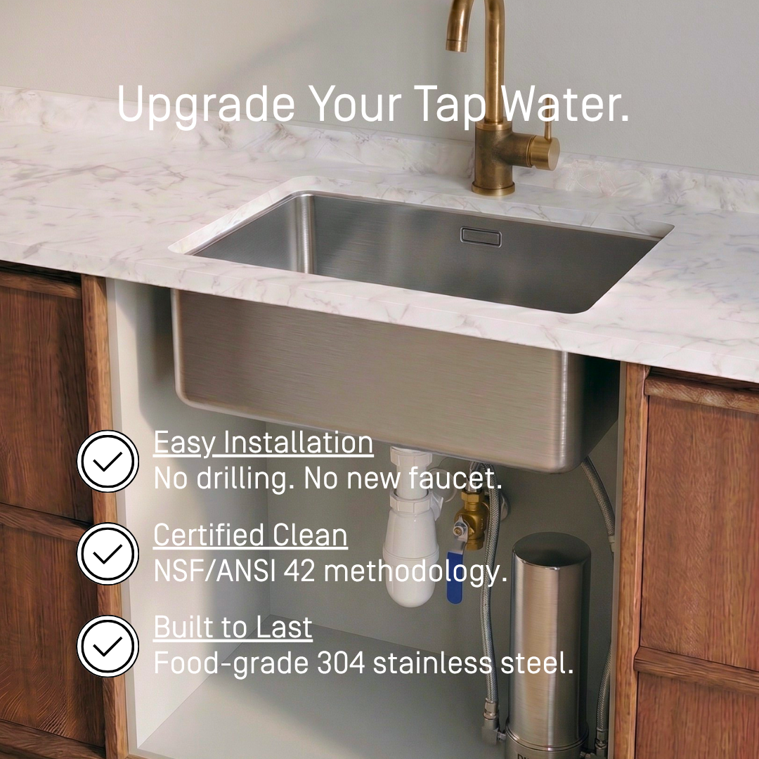 PJURE under-sink water filter installed beneath a kitchen sink with gold faucet — easy installation, NSF/ANSI 42 methodology tested, food-grade 304 stainless steel